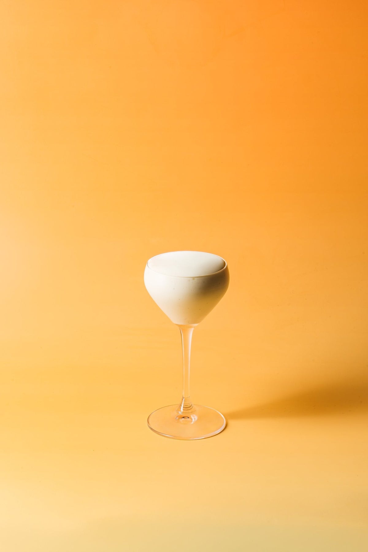 Lemon Sgroppino in a Nick & Nora glass, on orange