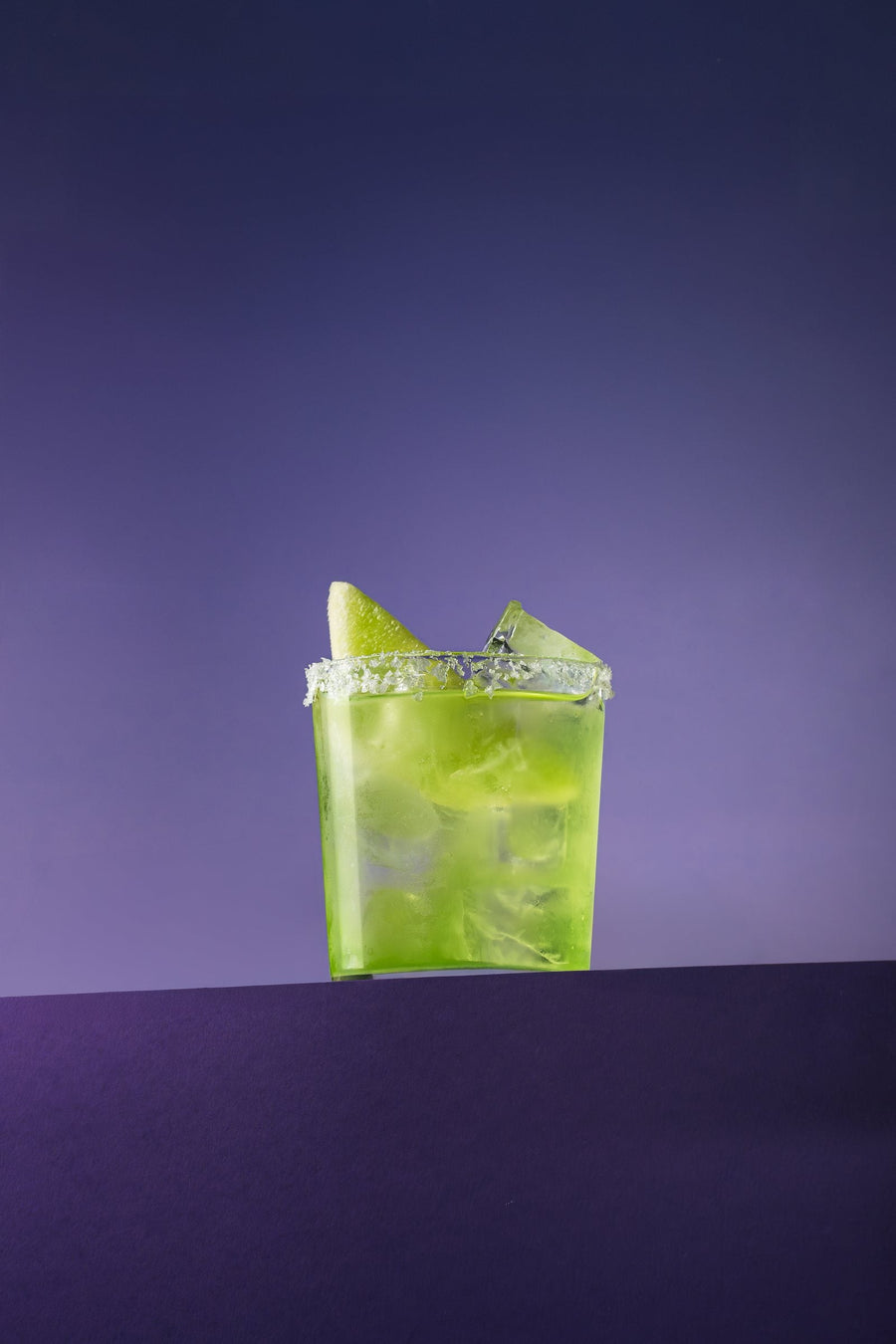 Melon Marg in a salt-rimmed rocks glass, on purple