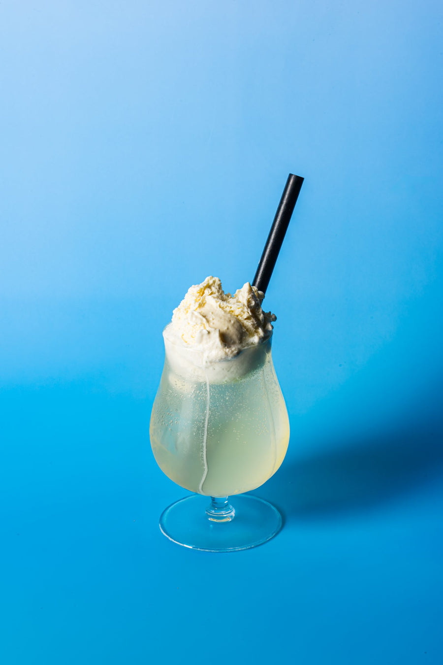 Lemon Spider in a hurricane glass with vanilla ice cream, on blue